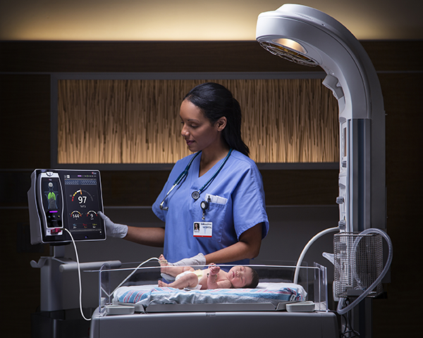 Un médico comprueba el monitor Root conectado a un bebé en la UCI neonatal