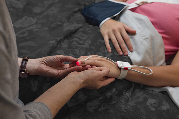 un padre que coloca un sensor en la mano de un niño