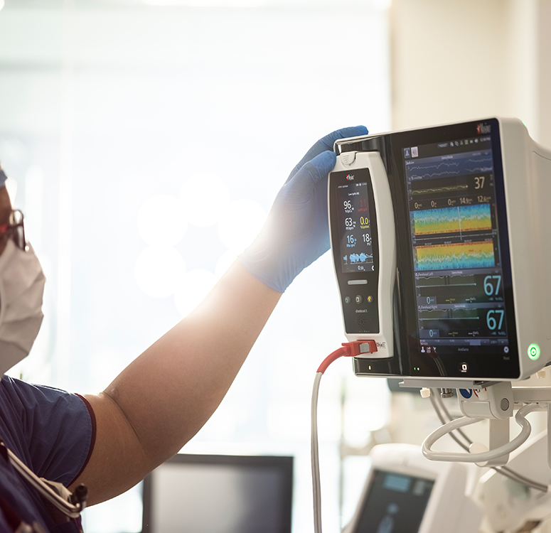 Un profesional sanitario interactúa con un sistema de monitorización de pacientes de Masimo que muestra tendencias avanzadas de las constantes vitales.